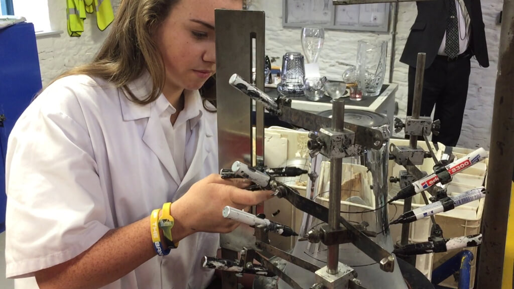 She's marking the crystal with markers that are attached to stands. These stands ensure straight level lines.